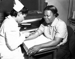 Nurse gives injection to woman, New Orleans, 1941. Original caption for photo set: "Statewide Public Health Project (Negro). This project is making an important contribution to pub