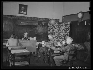 Three pupils share lunchtime together in a small rural schoolhouse in Williams County, North Dakota.